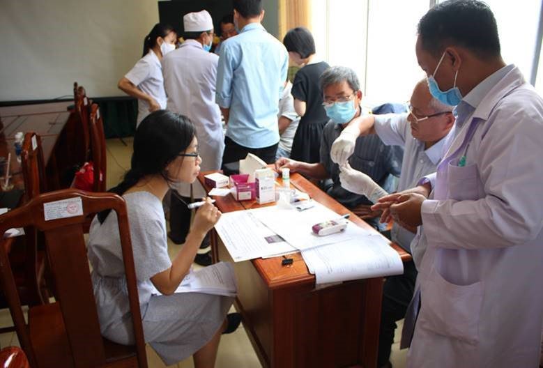 Huyen Nguyen of PATH (seated on left) observes health care staff in Binh Phuoc Province, Vietnam, after a training session on G6PD testing to assess staff proficiency and competency. Photo: PATH/Spike Nowak.