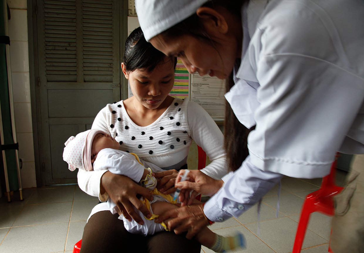 A health worker administers a vaccine to a child.