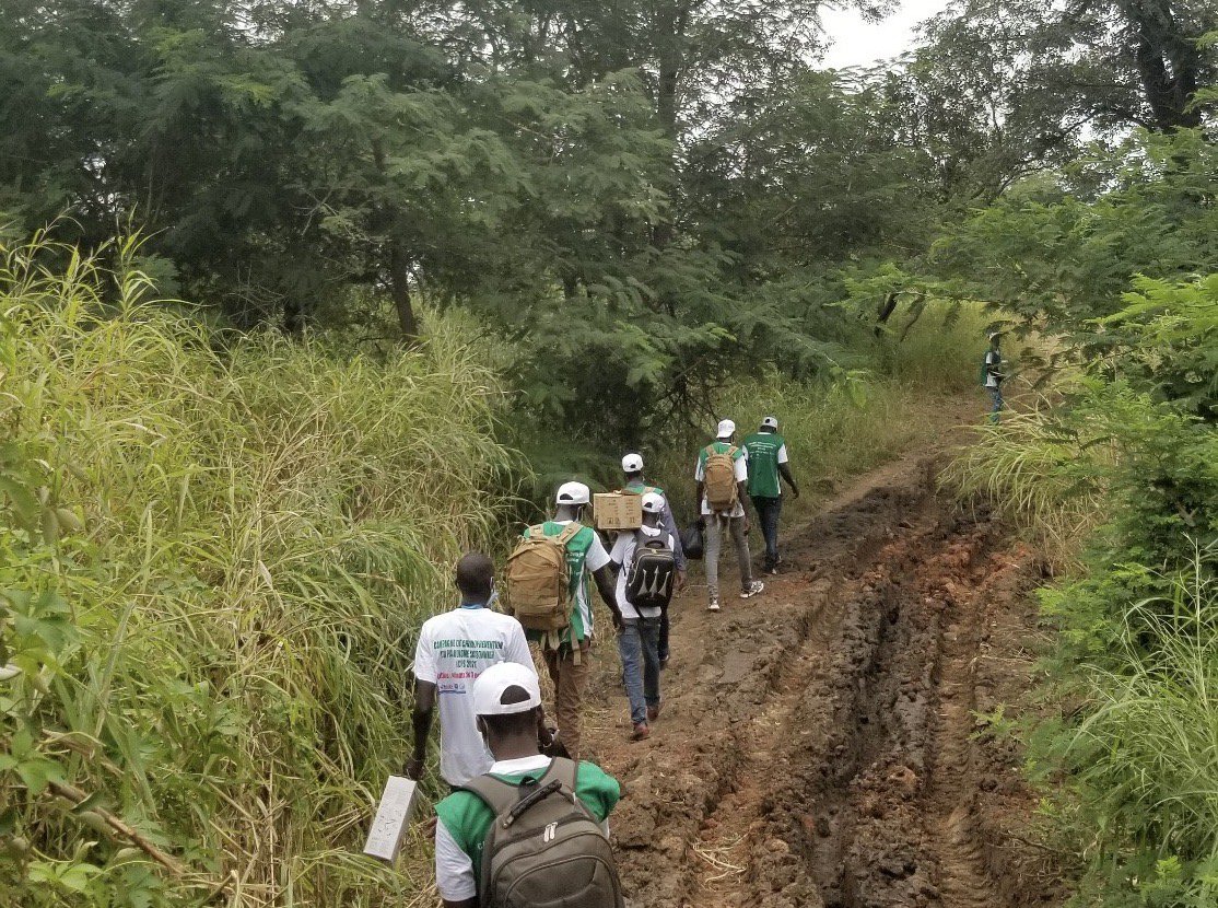 PATH and Saraya District staff walk to gold mining sites in Saraya District, Senegal, to conduct a malaria survey among gold miners in October 2021. Photo: PATH/Henry Ntuku.