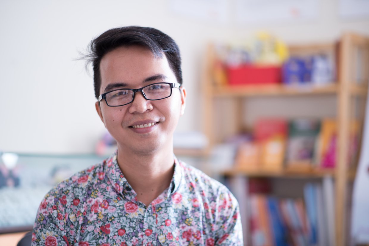 Young man wearing a floral print shirt.