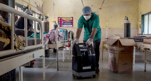 A new oxygen concentrator procured and delivered by PATH is set up at the bedside of a COVID-19 patient in an isolation ward at Palghar Rural Hospital, Maharashtra. Photo: PATH/Ragul Krishnan.