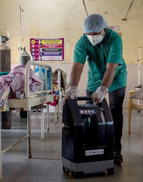 A new oxygen concentrator procured and delivered by PATH is set up at the bedside of a COVID-19 patient in an isolation ward at Palghar Rural Hospital, Maharashtra. Photo: PATH/Ragul Krishnan.