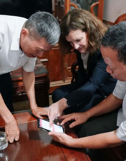 4. A commune health worker guides a patient with hypertension to update their blood pressure on the Sức Sống Mới application during a home visit.