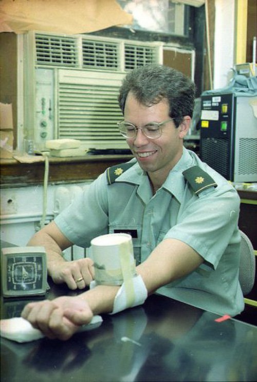 An archival photo of Rip Ballou with an ice-cream carton filled with malaria-infected mosquitoes taped to his arm.