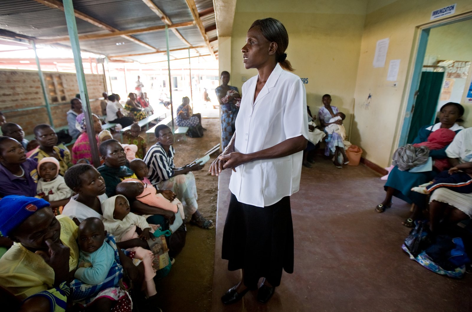 A health provider talks to mothers as they hold their infants