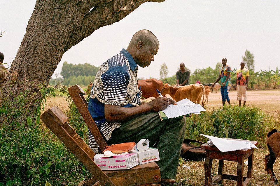 Photo: During a routine vaccination drive to immunize farm animals against anthrax, Vincent Kanyanya, local council chairperson of Namawanga village, completes paperwork for the Mbale District veterinary laboratory.