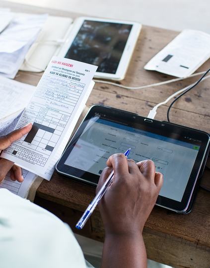 A medical worker enters data on a digital tablet. Photo: PATH.