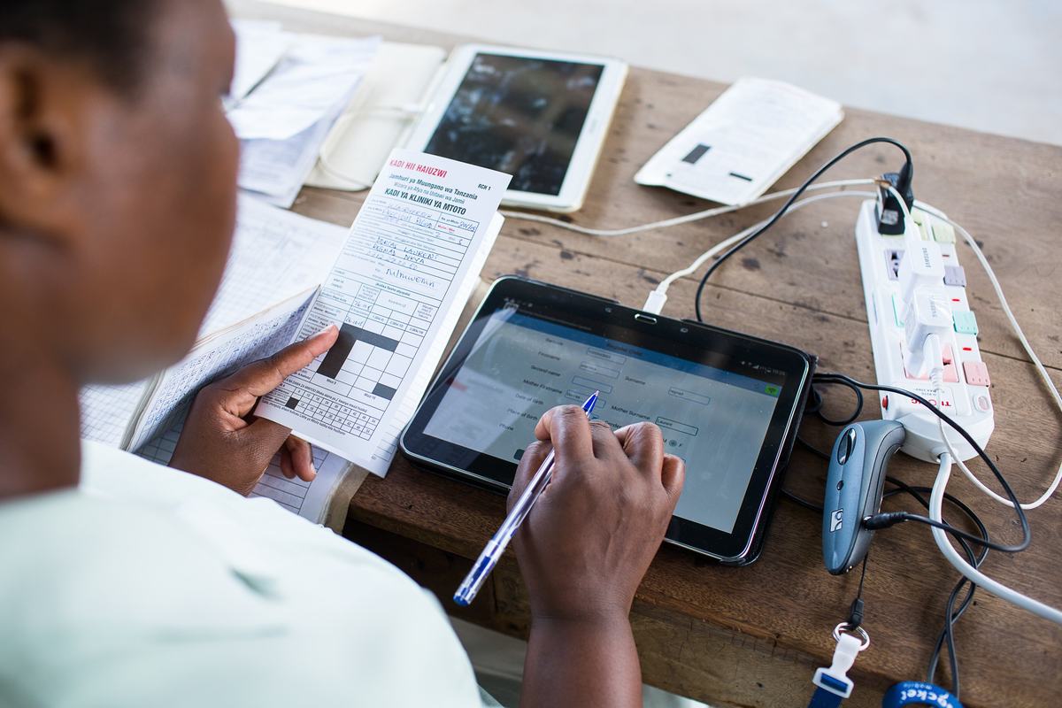 A medical worker enters data on a digital tablet. Photo: PATH.