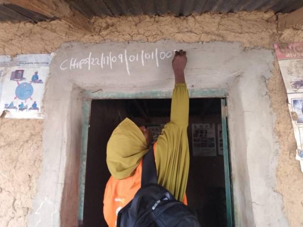 A community health worker conducts household numbering in her community as part of the Rotary Healthy Communities Challenge project.