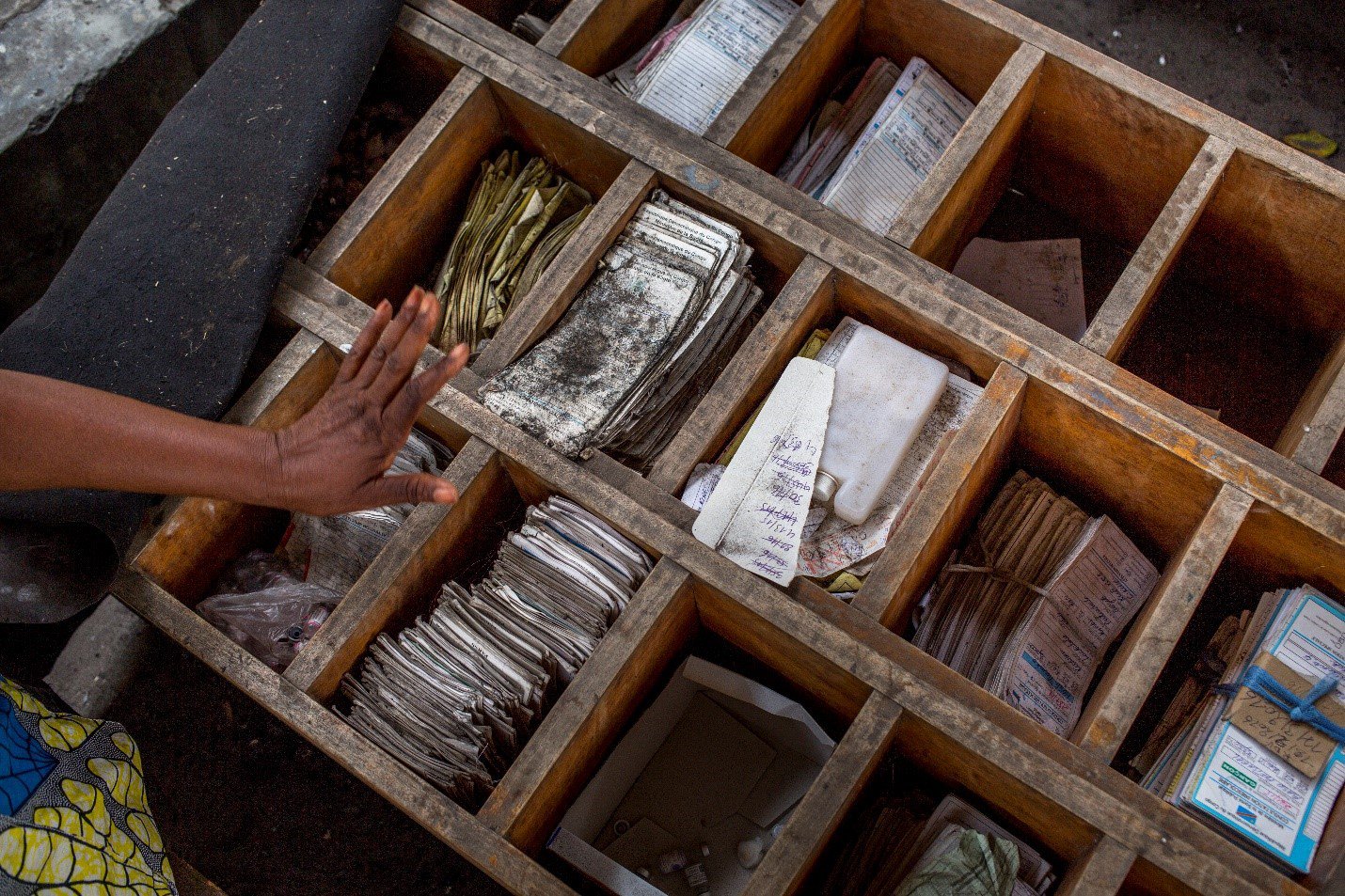 An open drawer with many compartments holds paper vaccine reords.