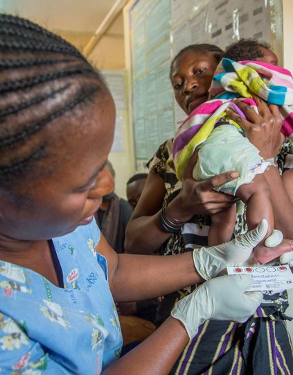 A nurse in Lubumbashi in southeastern DRC gently collects a dried blood spot sample from a newborn, illustrating the routine yet transformative intersection of integrated disease management and primary health care. Photo: PATH/Georgina Goodwin.