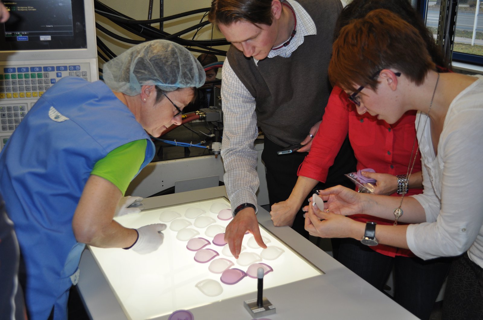 Kessel staff examine a group of diaphragms on top of a laboratory lightbox.