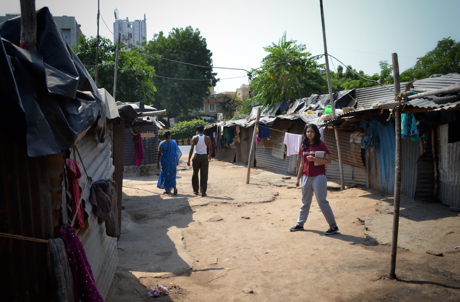 woman with notebook among shanties in India