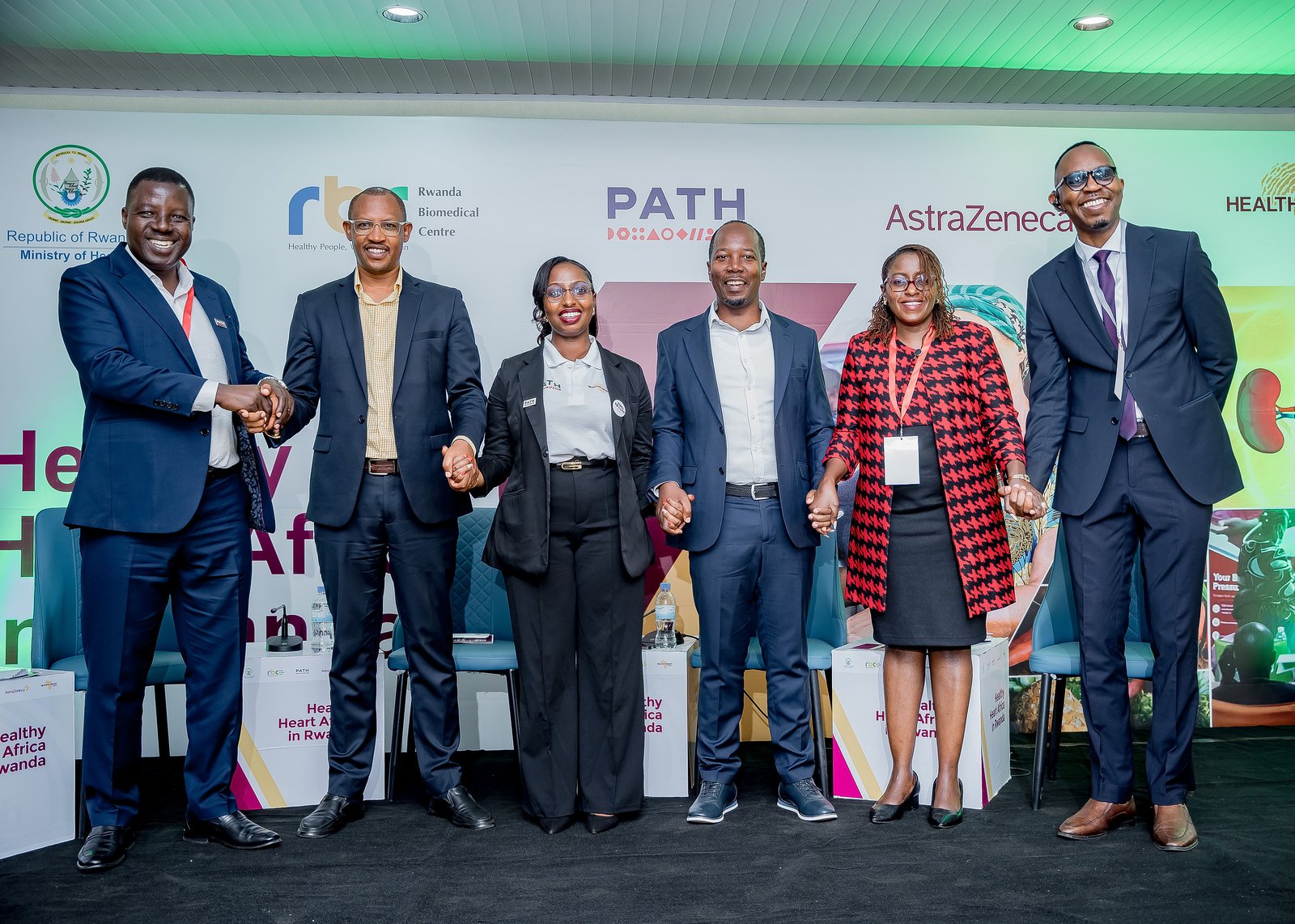 Leaders from AstraZeneca, RBC, PATH, Gatsibo District, and Rwanda’s Ministry of Health join hands to mark the launch of the expanded HHA program in Rwanda. Photo: PATH/Kanyarwanda Arts.
