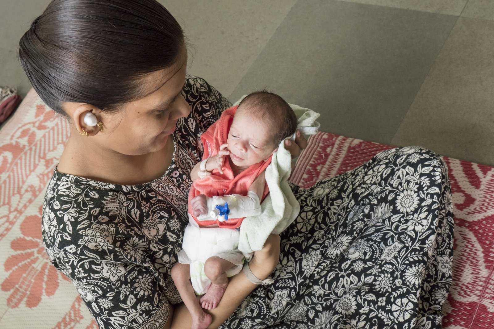 A woman holds a newborn baby.