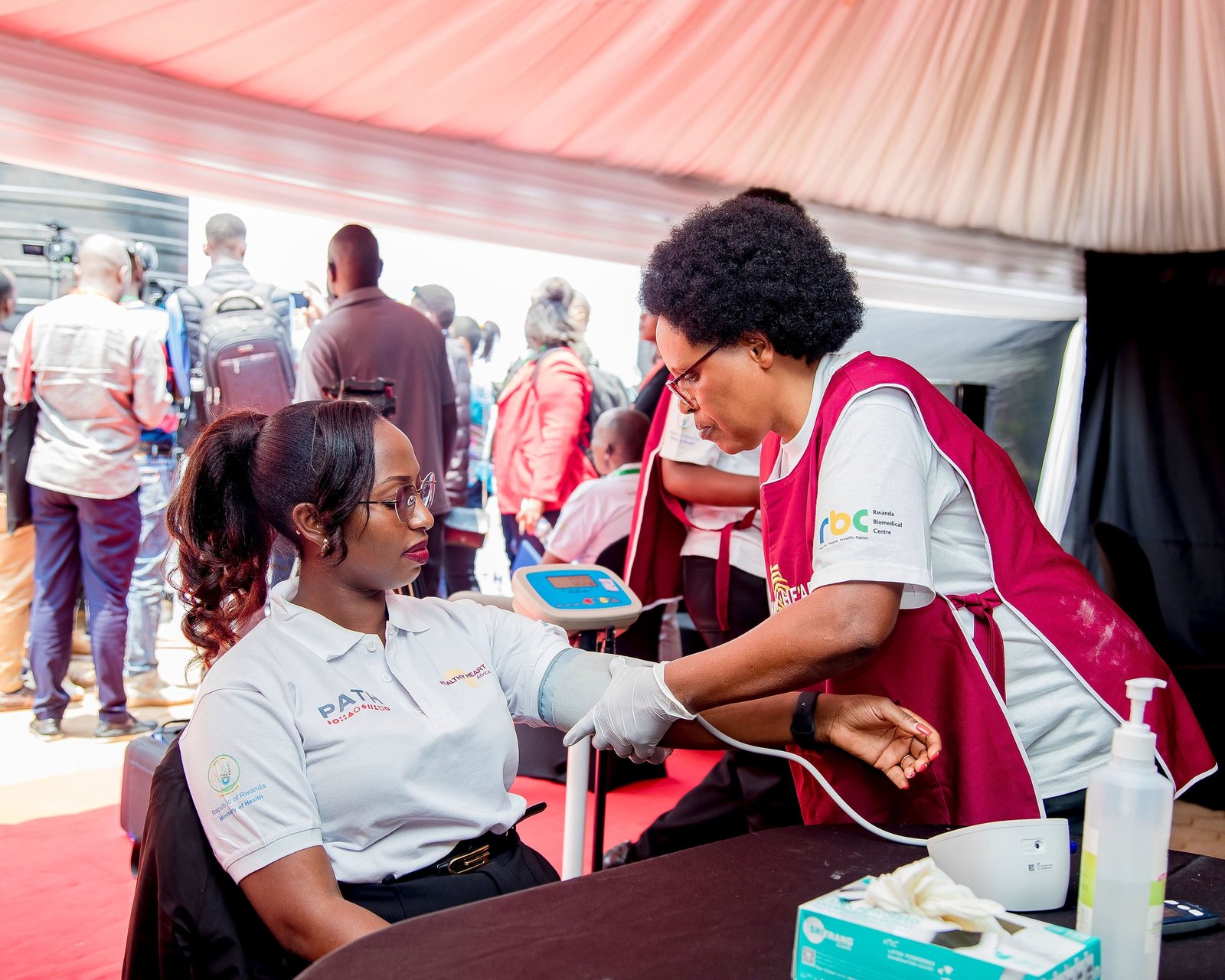 A community health care worker conducts a live screening demonstration with Dr. Florence Sibomana, NCDs Program Lead at PATH Rwanda. Photo: PATH/Kanyarwanda Arts.