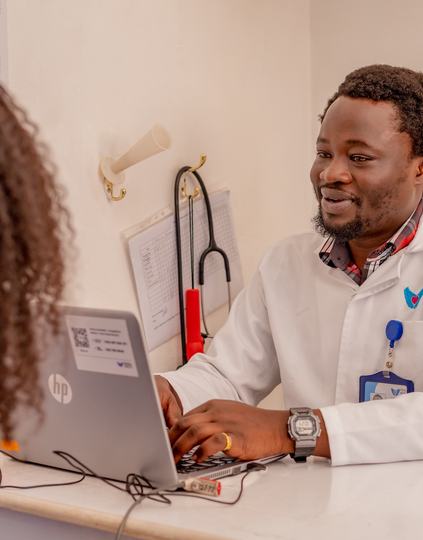 A Penda Health clinician reviews information in the clinic's electronic medical record, which includes an integrated AI consult tool for clinical decision support. Photo: PATH.