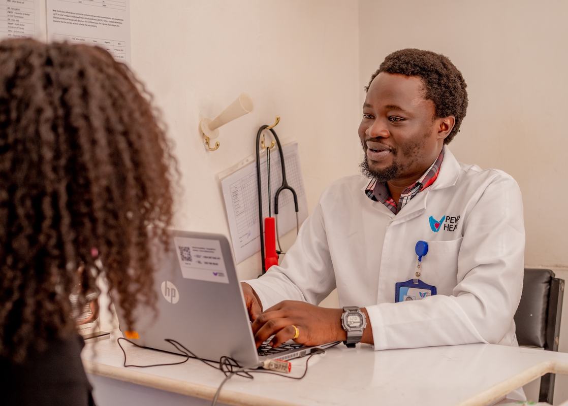A Penda Health clinician reviews information in the clinic's electronic medical record, which includes an integrated AI consult tool for clinical decision support. Photo: PATH.