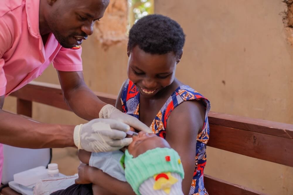 A health worker (left) vaccinates a child at a health facility in Ntungamo District, Southwestern Uganda. Photo: PATH.