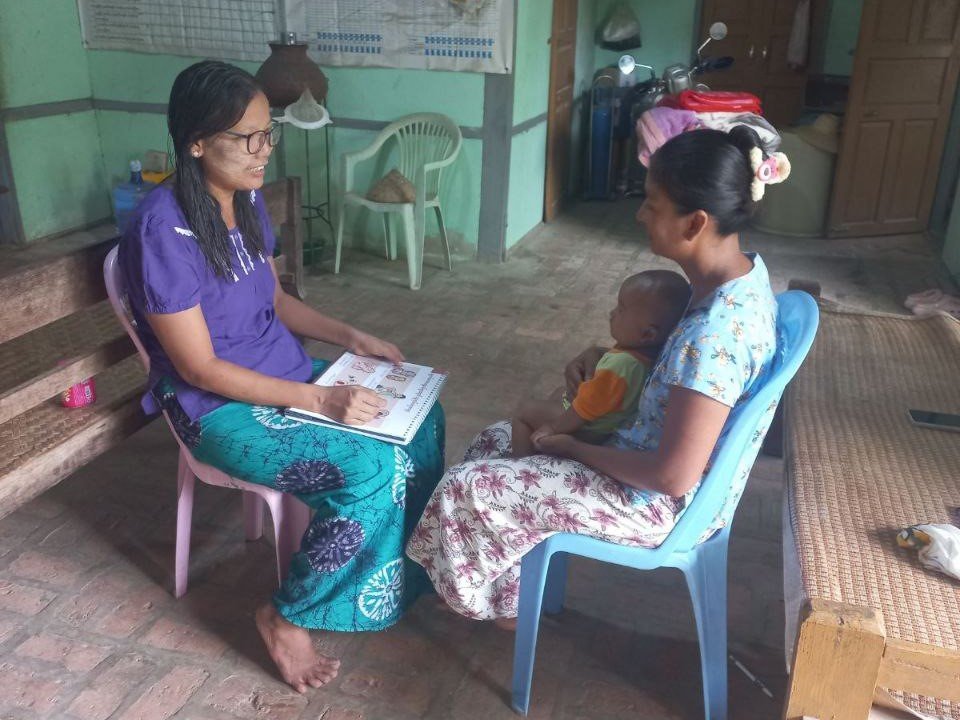 A service provider providing mental health support to a mother using a PMH flip chart. Photo: PATH