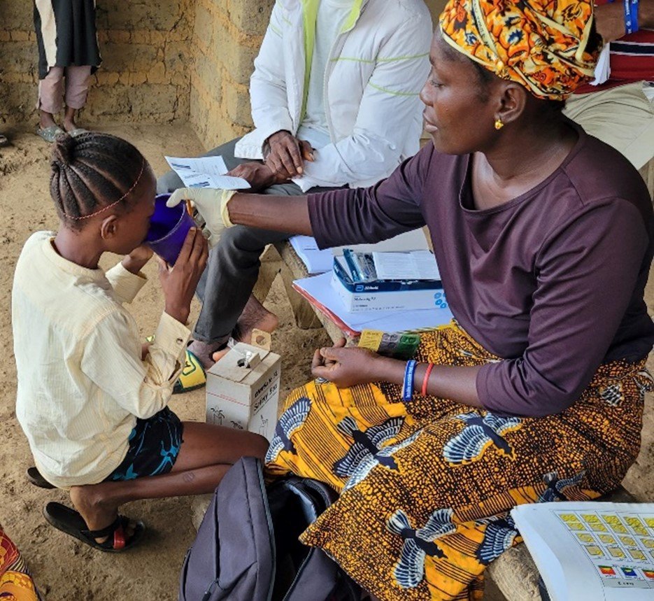 A community health worker administers antimalarial treatment to treat a case of malaria as part of proactive community case management, Pujehun District, Sierra Leone. Photo Credit: PMI Insights