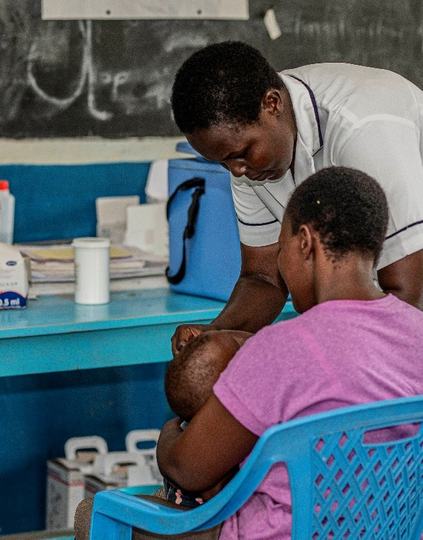 A nurse examines a child at a health facility in Homabay County, Kenya. Photo: PATH/Philip Mutuku.