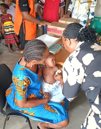 A community health worker screens a child for malnutrition using a mid-upper arm circumference strap during a community visit in Akwa Ibom State, Nigeria. Photo: Helen Keller Intl