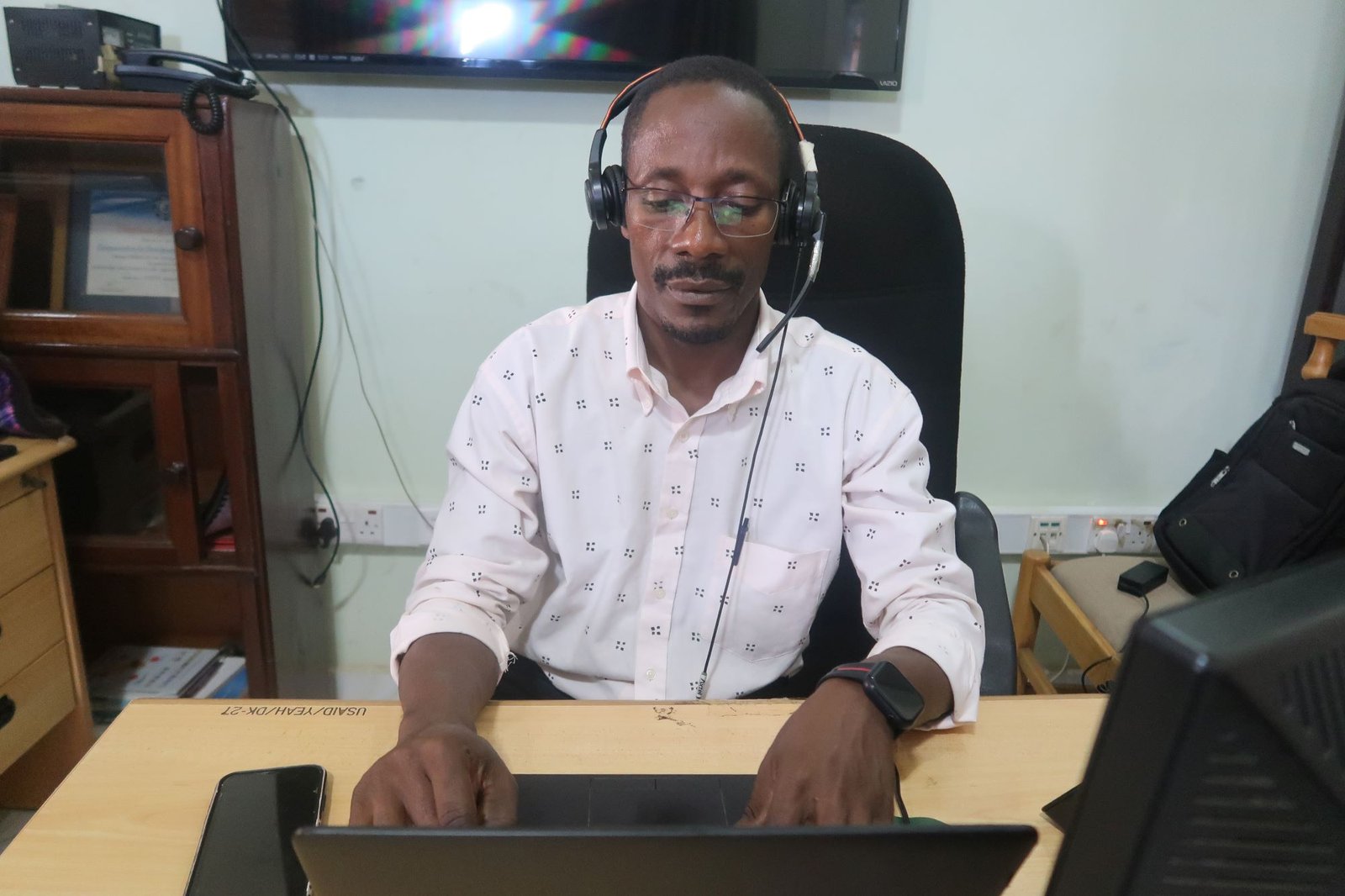 Ssekinkuse Julius, CDFU’s call center coordinator, responds to a call. Photo: Joseph Waninda/PATH.