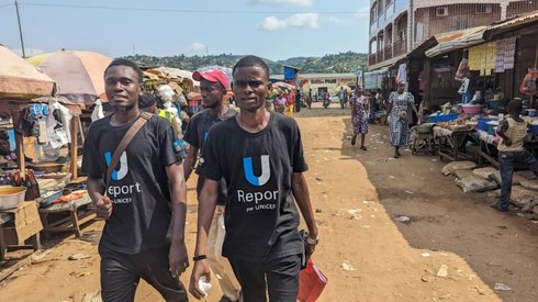 Youth club volunteers speak to market vendors in Kisantu while wearing PATH-issued awareness vests. The volunteers use simple, clear language to explain the vaccine and follow up on missed doses. Credit: UNICEF.