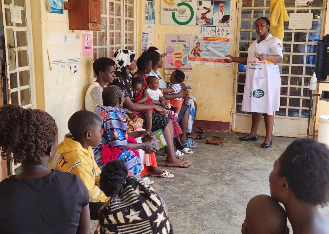Justine Gimbo, the Assistant Nursing Officer at Buyaga Health Centre II, Masaka District, explaining the malaria vaccine schedule to mothers. Photo: Joseph Waninda/PATH.